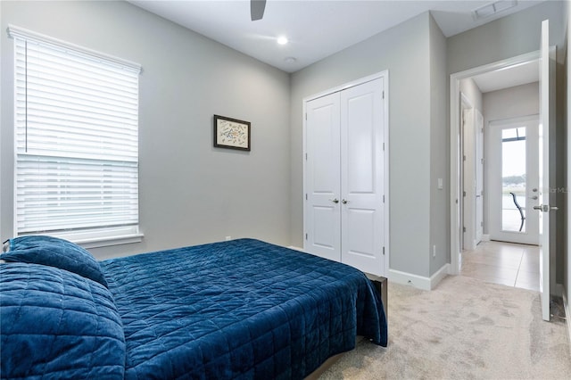 bedroom featuring ceiling fan, a closet, and light carpet