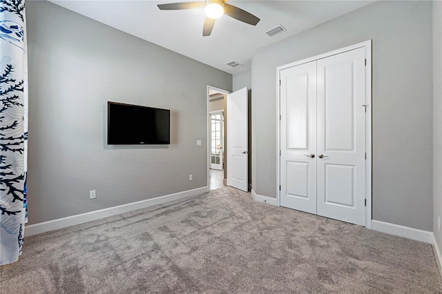 unfurnished bedroom featuring ceiling fan, a closet, and light carpet