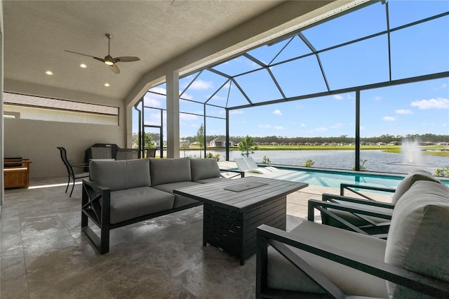 view of patio / terrace with an outdoor living space, a water view, ceiling fan, and a lanai