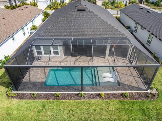 back of property featuring central AC, a lanai, a patio area, and a lawn