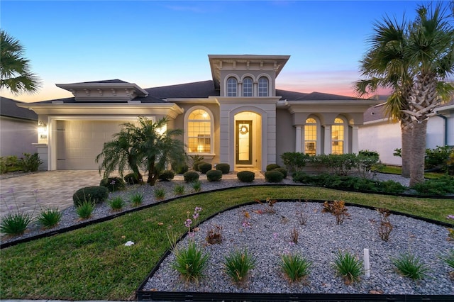 view of front of property featuring a garage and a lawn