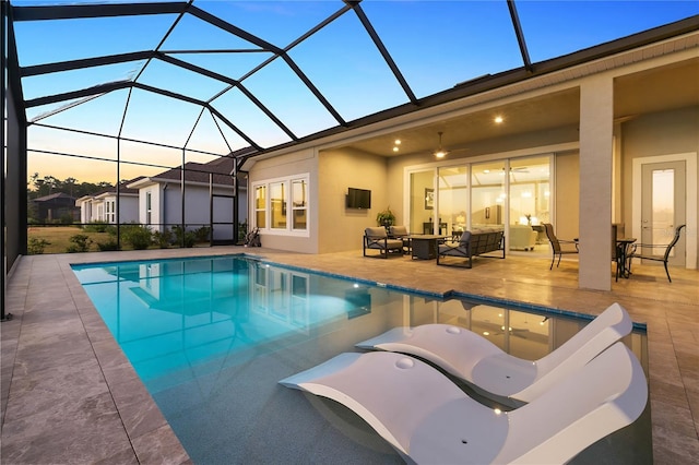 pool at dusk with an outdoor living space, a lanai, and a patio area