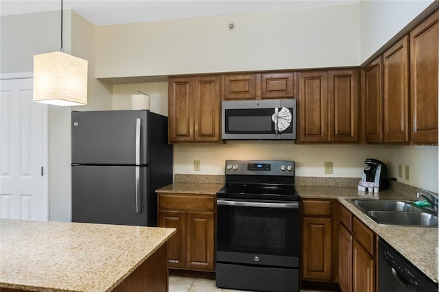 kitchen featuring sink, light tile patterned floors, hanging light fixtures, stainless steel appliances, and light stone counters