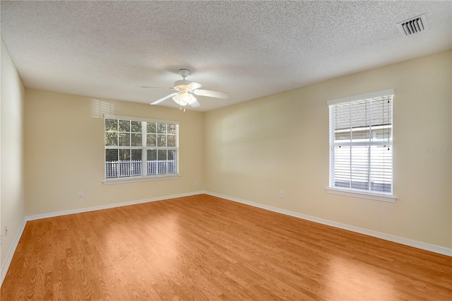 empty room featuring a textured ceiling, ceiling fan, and light wood-type flooring