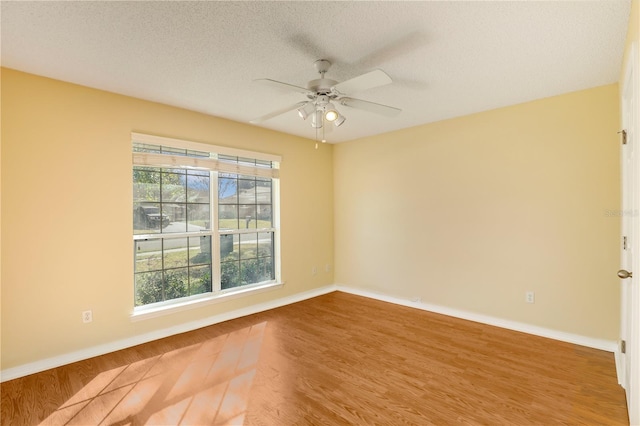 unfurnished room with hardwood / wood-style flooring, ceiling fan, and a textured ceiling