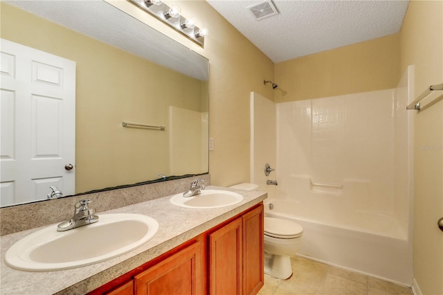 full bathroom featuring  shower combination, vanity, a textured ceiling, tile patterned floors, and toilet