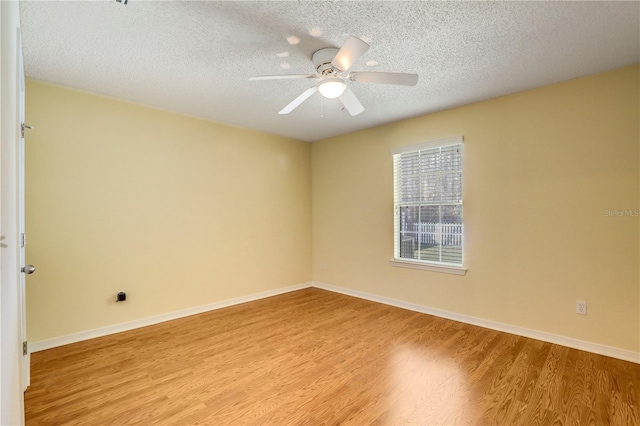 empty room with ceiling fan, a textured ceiling, and light wood-type flooring