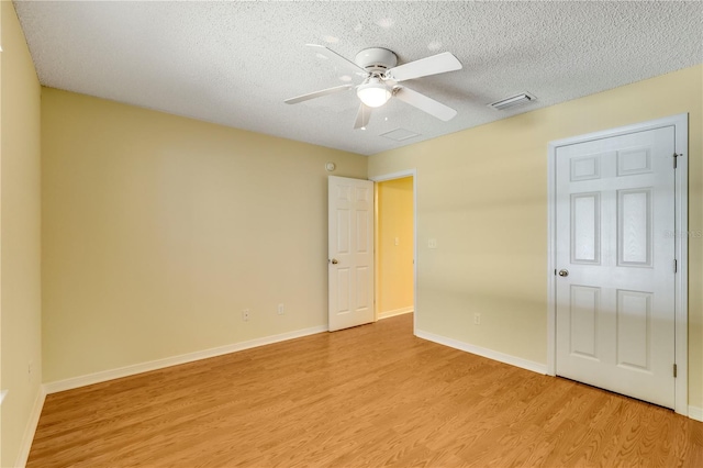 unfurnished bedroom featuring ceiling fan, light hardwood / wood-style floors, and a textured ceiling