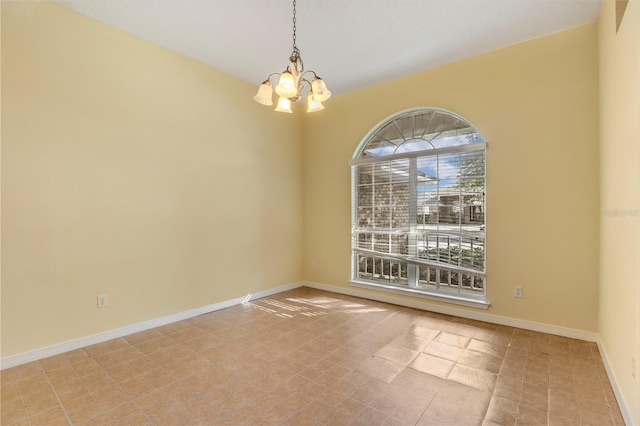 unfurnished room with a chandelier