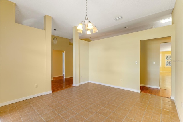 unfurnished room featuring a notable chandelier