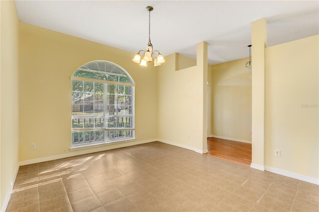 unfurnished room with a notable chandelier