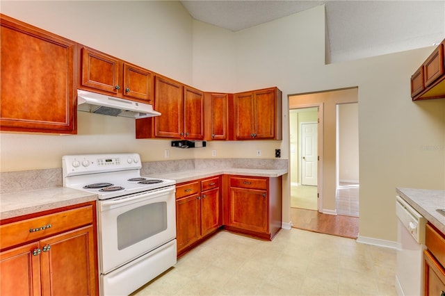 kitchen with white appliances and a towering ceiling