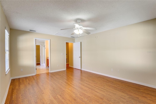 spare room featuring ceiling fan, a textured ceiling, and light hardwood / wood-style flooring