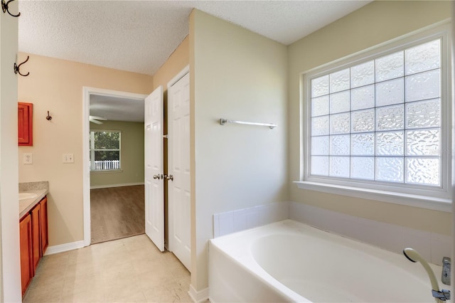 bathroom featuring vanity, a bathtub, and a textured ceiling