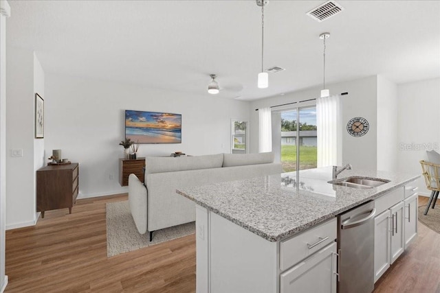 kitchen with a center island with sink, sink, stainless steel dishwasher, and white cabinets