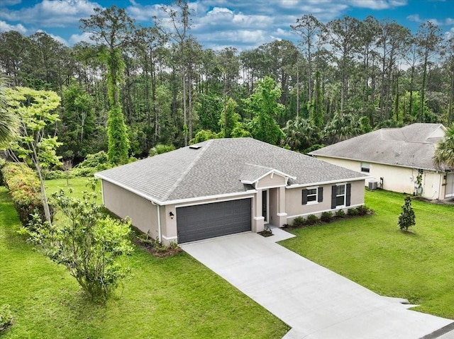 ranch-style house featuring a garage, a front yard, and central air condition unit