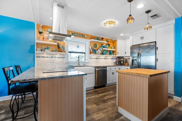 kitchen featuring a breakfast bar, white cabinetry, island range hood, appliances with stainless steel finishes, and backsplash