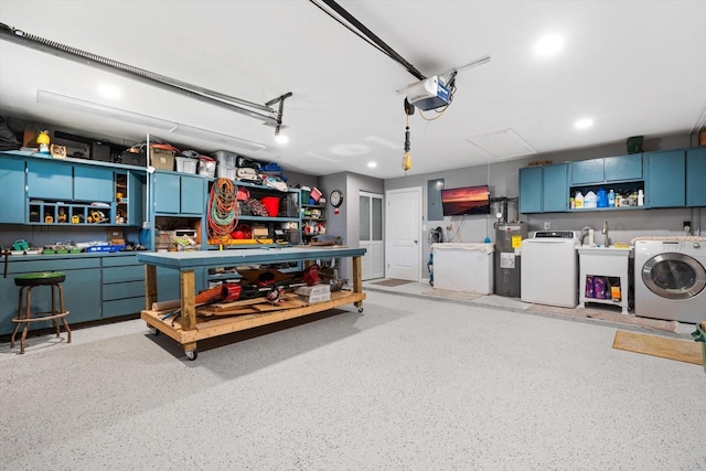 garage featuring a garage door opener, electric water heater, sink, and independent washer and dryer