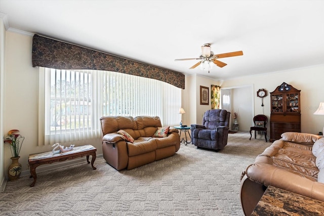 carpeted living room featuring ornamental molding and ceiling fan