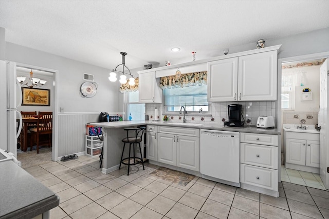 kitchen with pendant lighting, white cabinets, white appliances, and kitchen peninsula