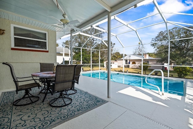 view of swimming pool with ceiling fan, a patio area, and glass enclosure