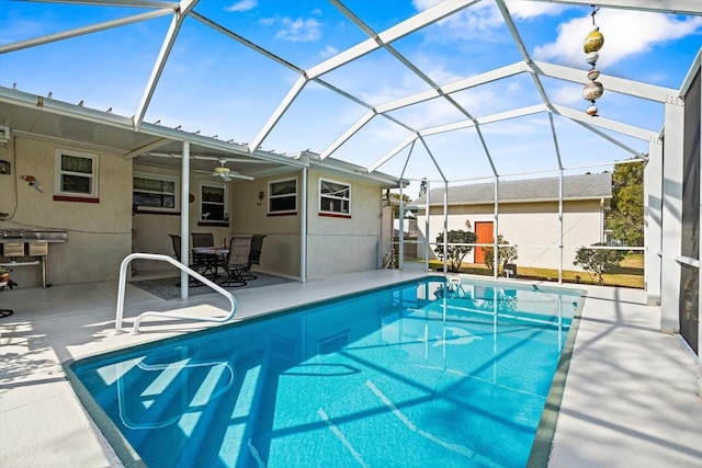 view of swimming pool with a patio, ceiling fan, and glass enclosure