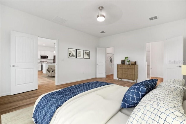 bedroom featuring wood-type flooring and a spacious closet