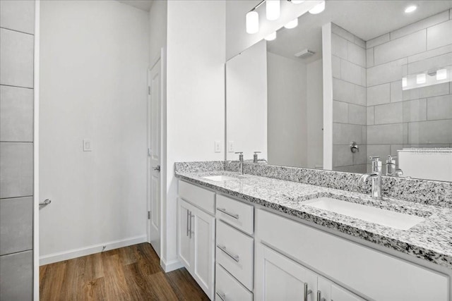 bathroom featuring vanity, hardwood / wood-style flooring, and a tile shower