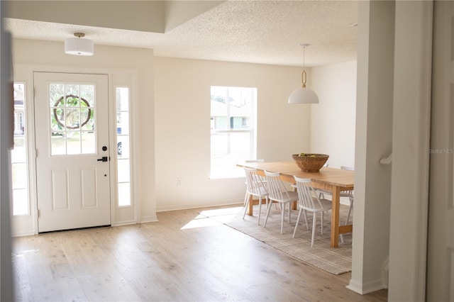 entrance foyer featuring a textured ceiling and light wood-type flooring