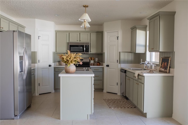 kitchen featuring light tile patterned floors, sink, appliances with stainless steel finishes, hanging light fixtures, and a kitchen island