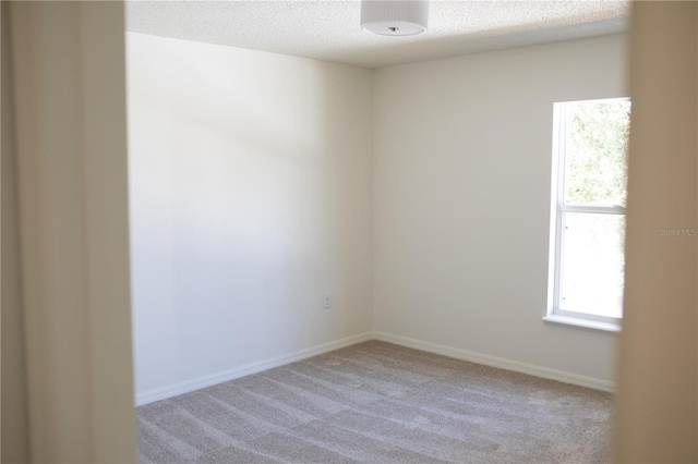 carpeted spare room with a textured ceiling