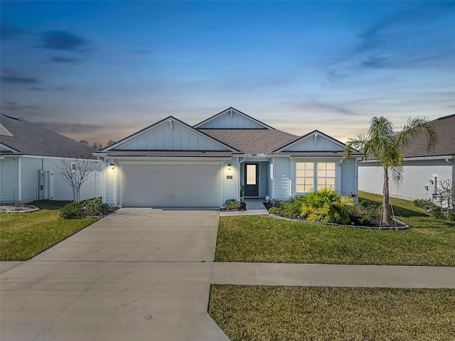 ranch-style house with a garage and a lawn