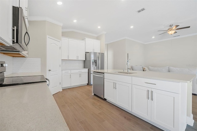 kitchen with light wood-type flooring, stainless steel appliances, a kitchen island with sink, and white cabinets