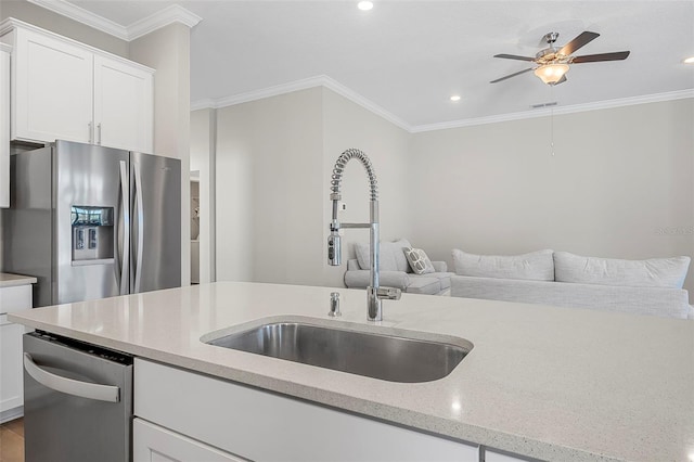 kitchen with stainless steel appliances, ornamental molding, sink, and white cabinets