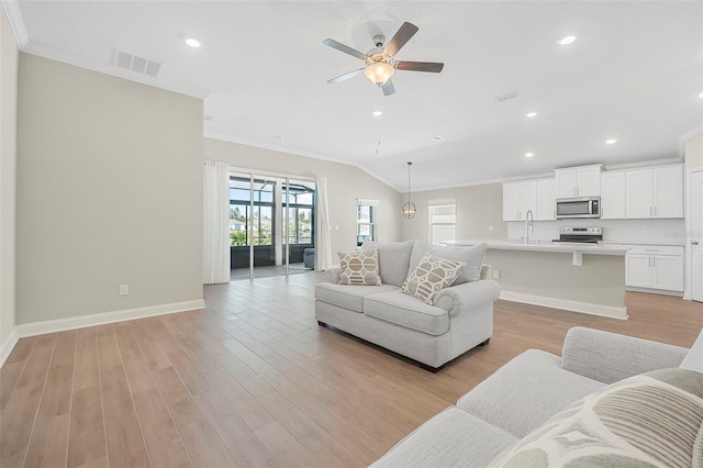 living room with lofted ceiling, sink, crown molding, ceiling fan, and light hardwood / wood-style floors