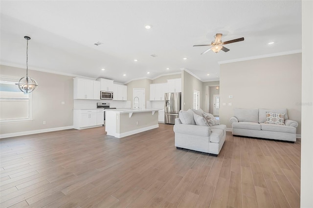 unfurnished living room featuring sink, crown molding, vaulted ceiling, and light hardwood / wood-style floors