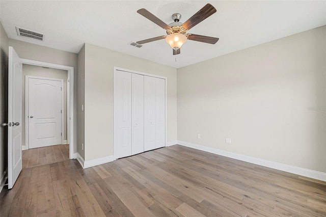 unfurnished bedroom with light hardwood / wood-style flooring, a closet, and ceiling fan