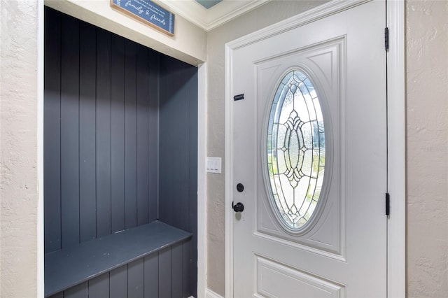 interior space featuring crown molding and a textured wall