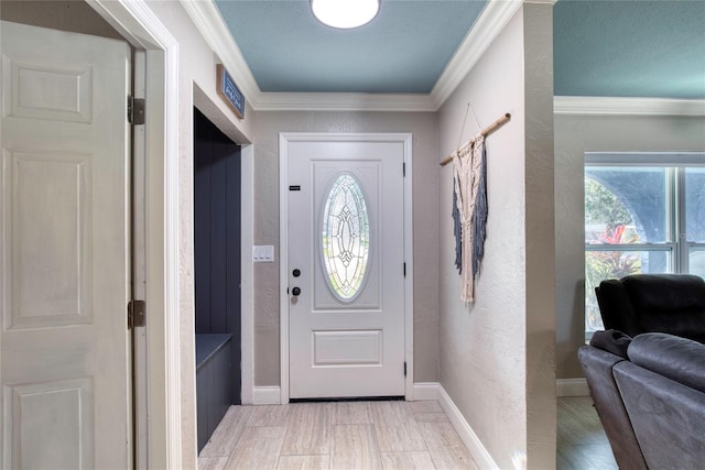 foyer with baseboards, visible vents, a textured wall, ornamental molding, and light wood-style floors