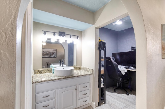 bathroom featuring a textured wall and vanity