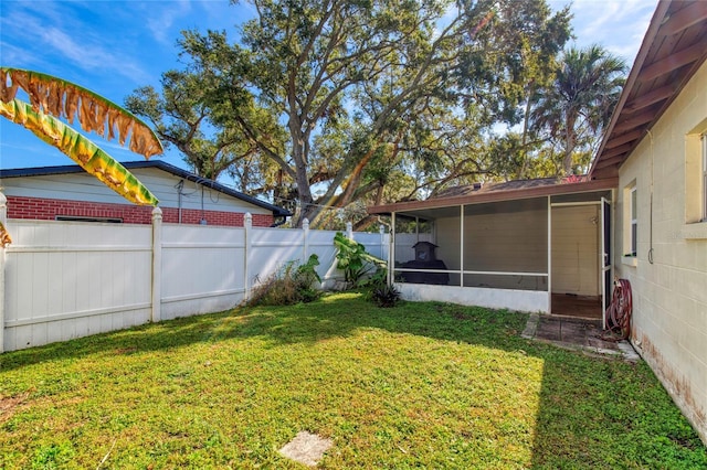 view of yard with a sunroom and a fenced backyard