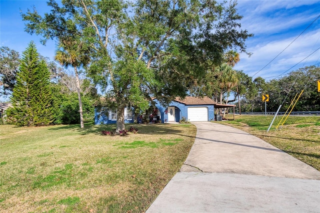 view of front of house featuring a front yard, concrete driveway, and an attached garage