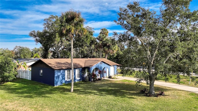 view of front facade with driveway, a garage, fence, and a front yard