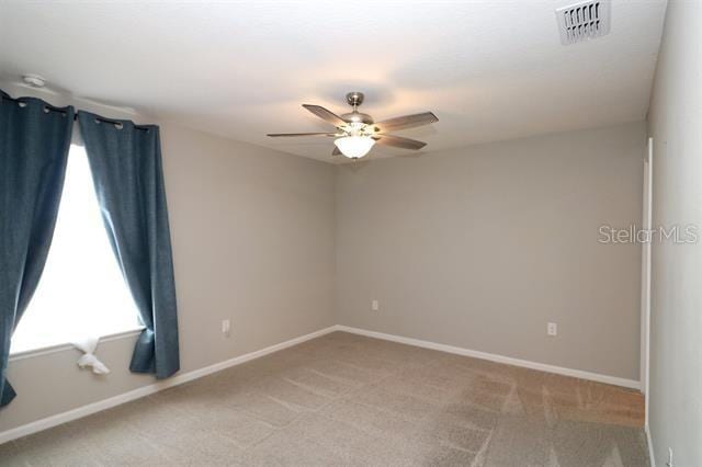 unfurnished room featuring light colored carpet and ceiling fan