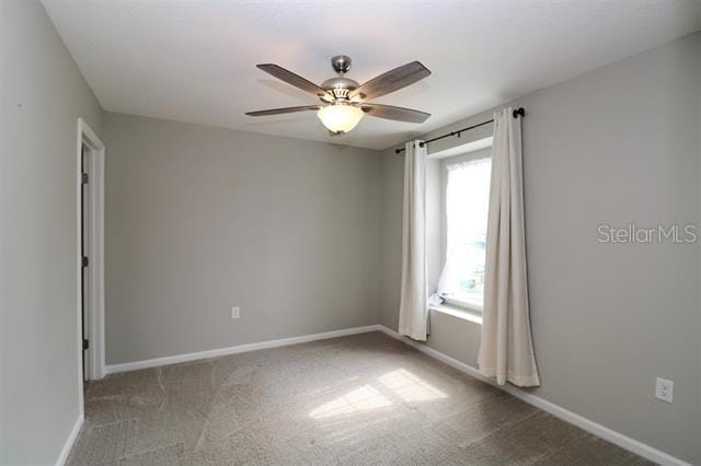 spare room with carpet floors and ceiling fan