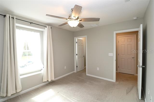 unfurnished bedroom with ceiling fan and light carpet