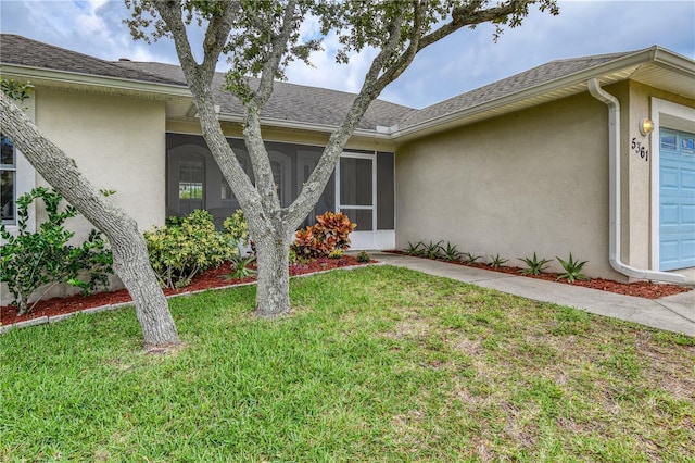 property entrance featuring a garage and a lawn