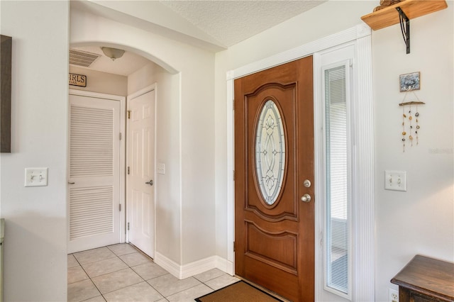 tiled foyer entrance with a textured ceiling