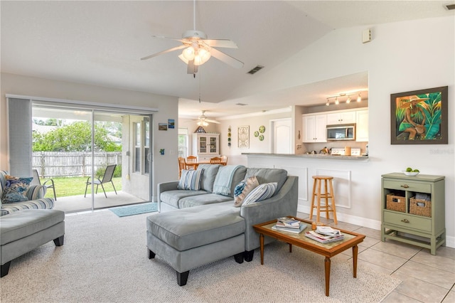 living room with ceiling fan, lofted ceiling, and light tile patterned floors