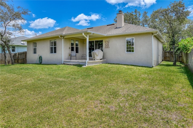 rear view of house featuring a lawn and a patio area